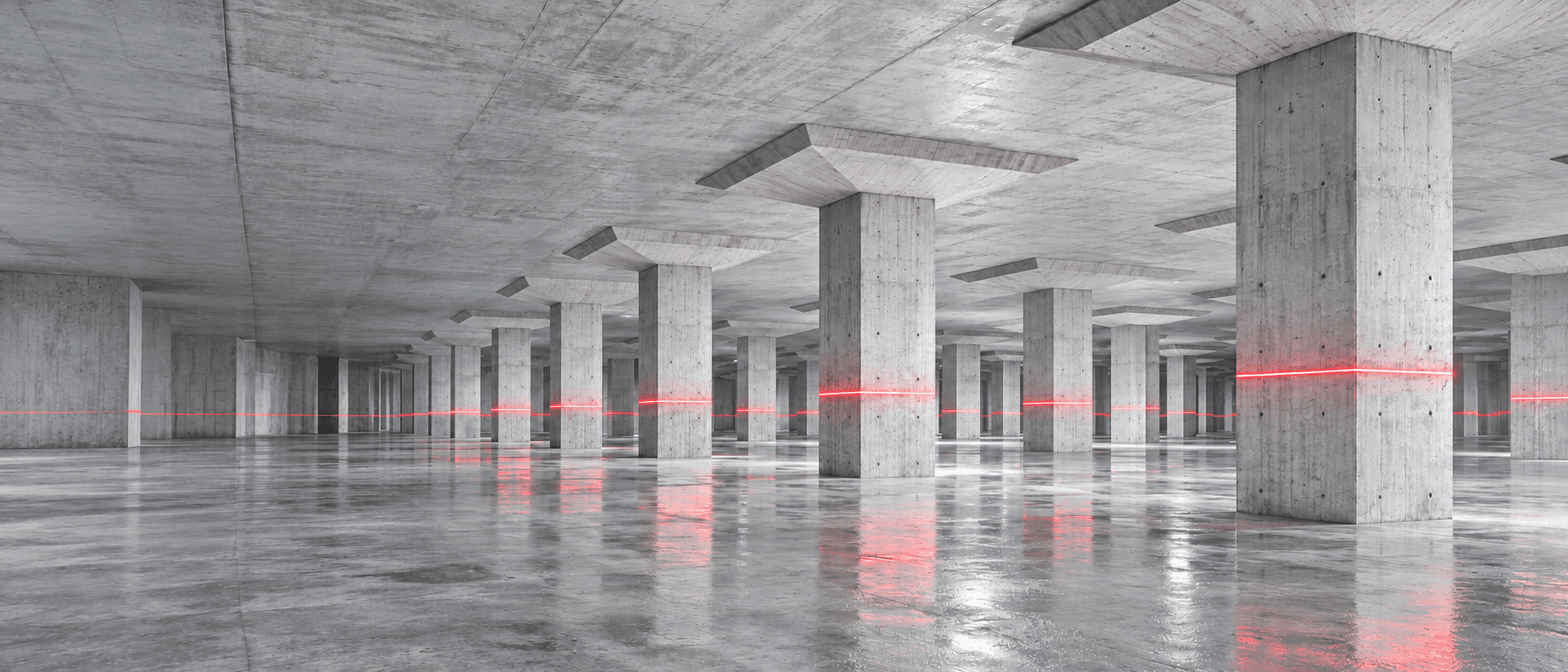 Daylit concrete basement with a red survey laser line across the columns